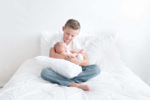 brother holding newborn baby
