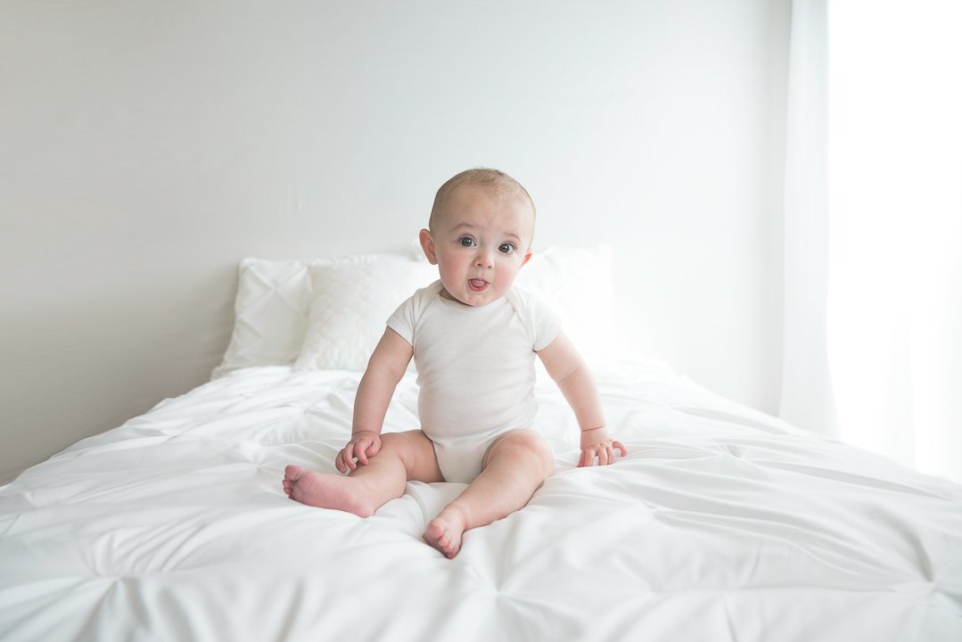 baby photographer shows baby sitting in studio