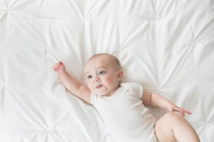 sitter baby on white bedding