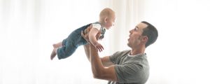 baby photographer shows father lifting baby