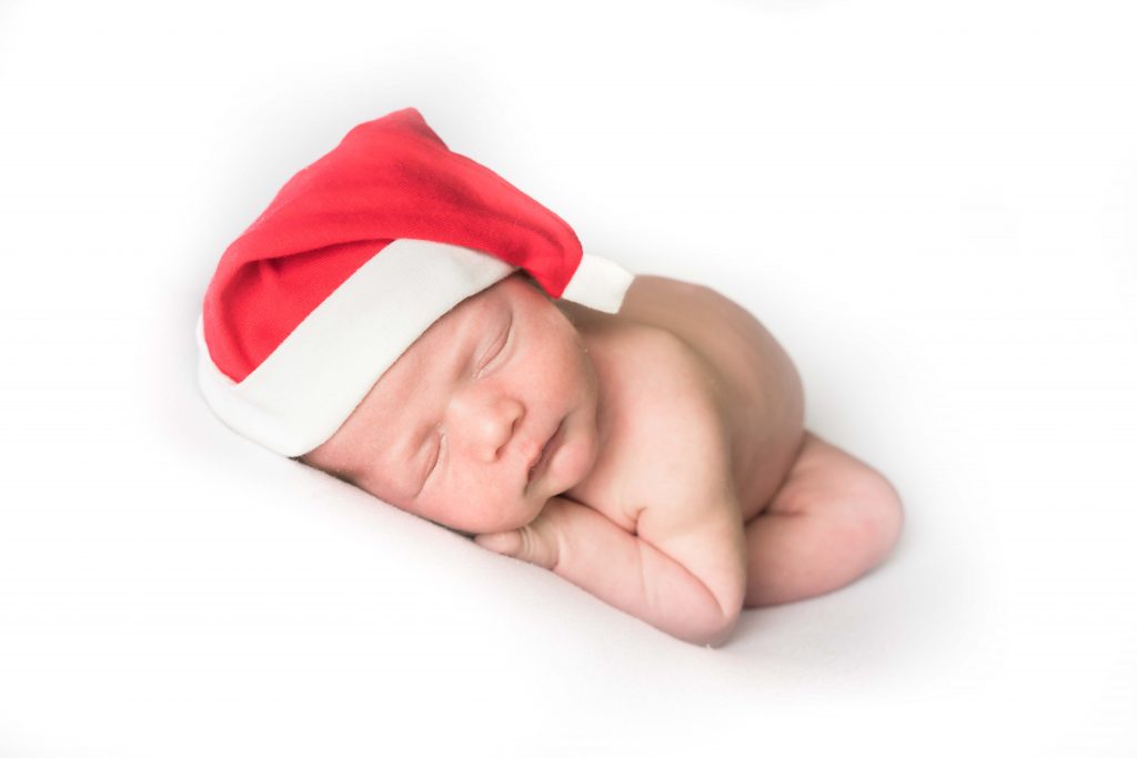 baby photographer shows baby boy with santa hat